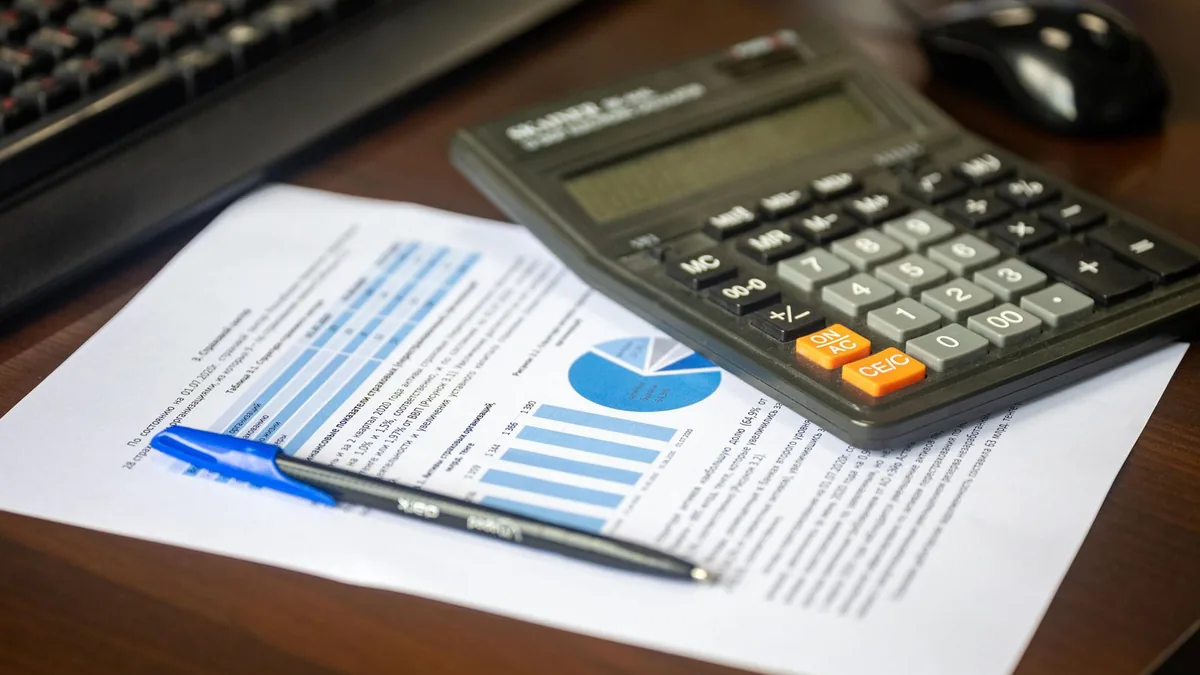 Calculator and financial report on a desk, the daily work of a fractional CFO for MSPs