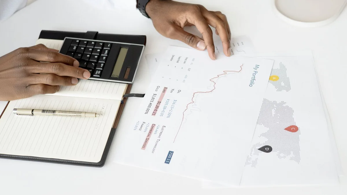 Hands reviewing financial documents with a calculator to prepare an MSP for an exit