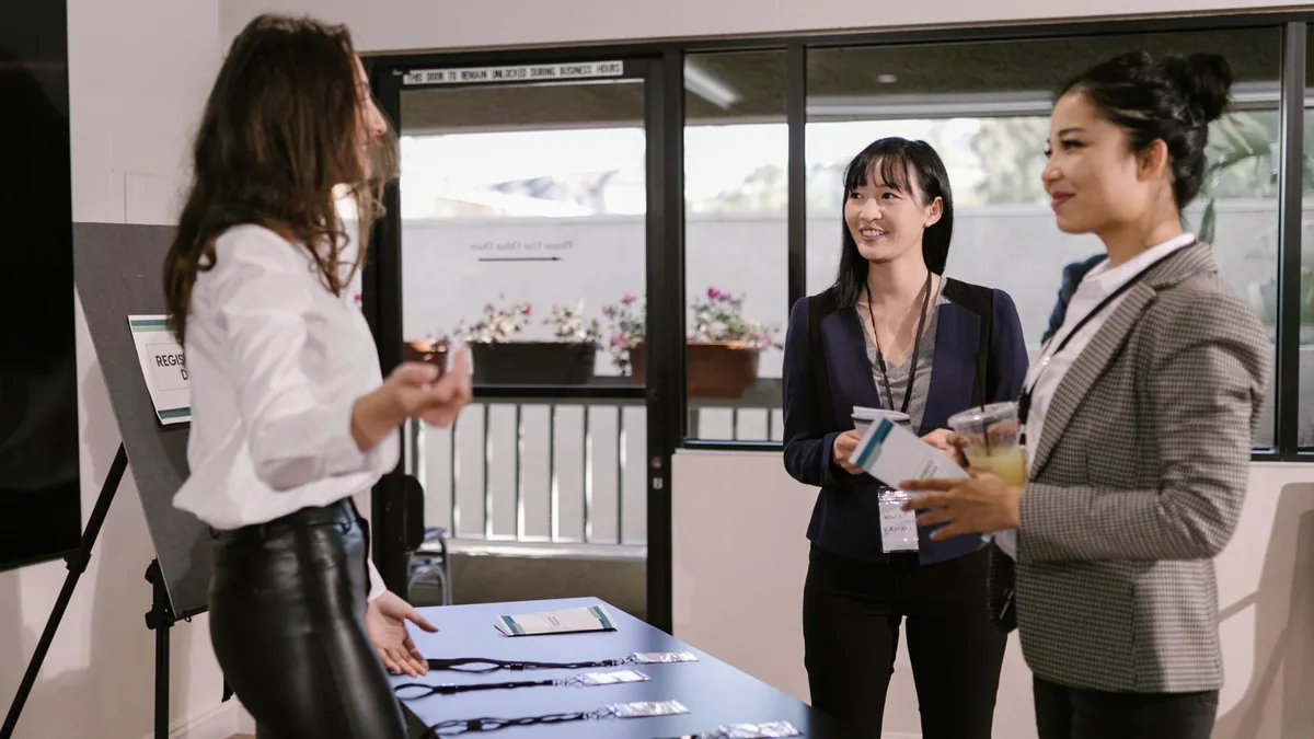 Professionals talking at a conference booth, the B2B networking LinkedIn marketing agencies for MSPs replicate online