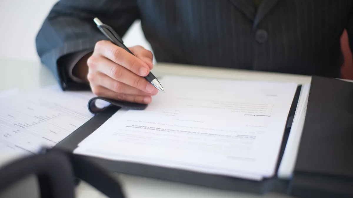 Business owner signing a sale agreement, the moment MSP business brokers work toward