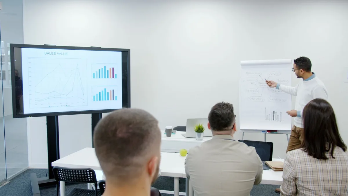 MSP sales consultant presenting a sales plan to a team in a meeting room
