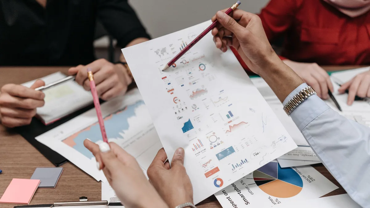 Fractional CFO cost review: leadership team marking up printed financial reports