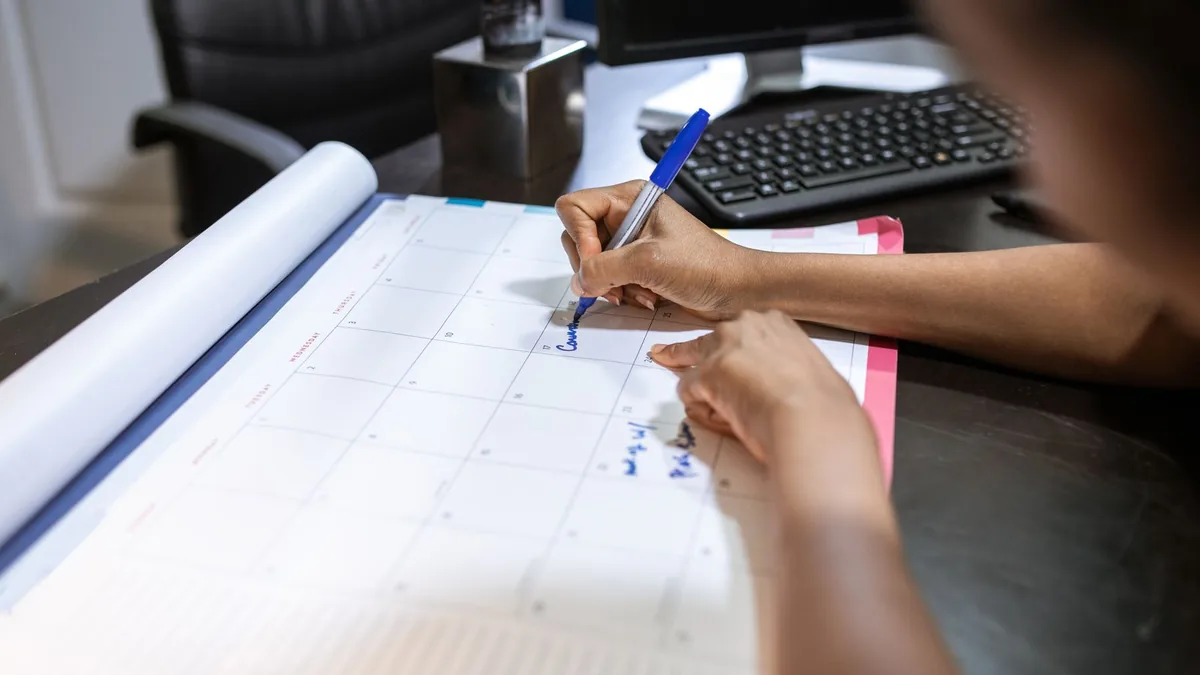Person scheduling meetings on a desk calendar for MSP appointment setting