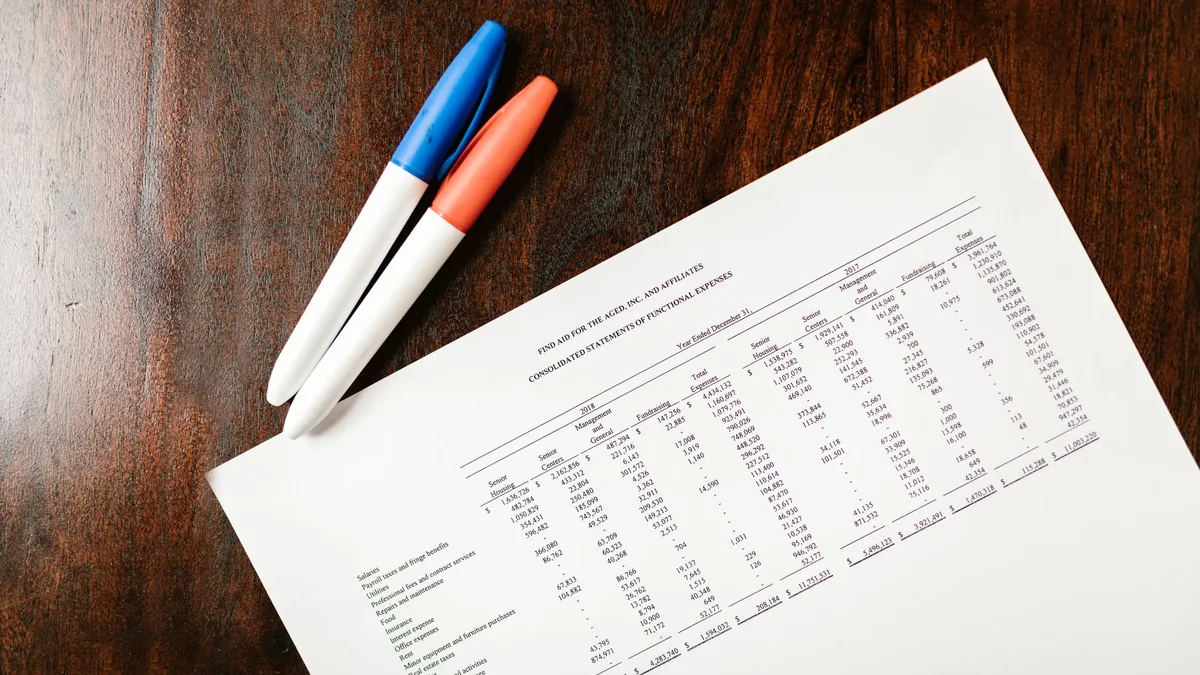 Pens resting on a printed MSP financial statement with rows of numbers