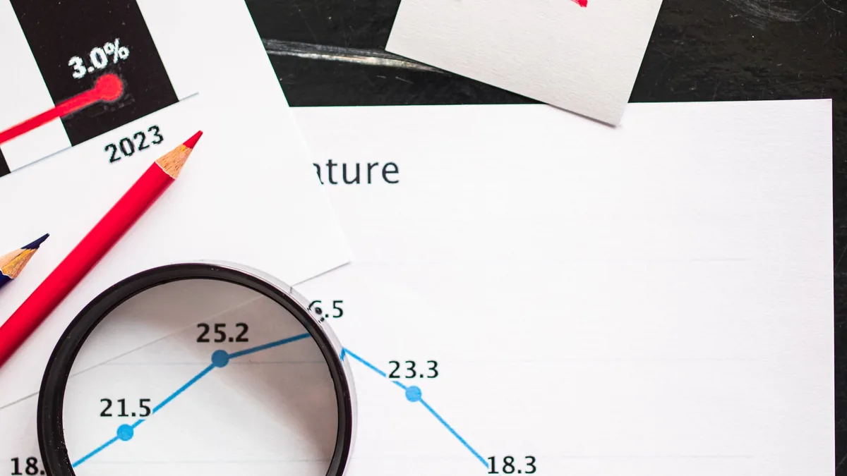 Magnifying glass over a report showing declining percentage figures, checking MSP financial metrics