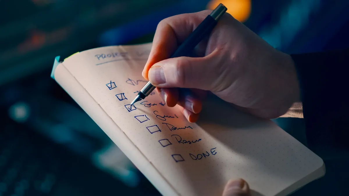 Checking off steps in a written marketing SOP checklist by hand
