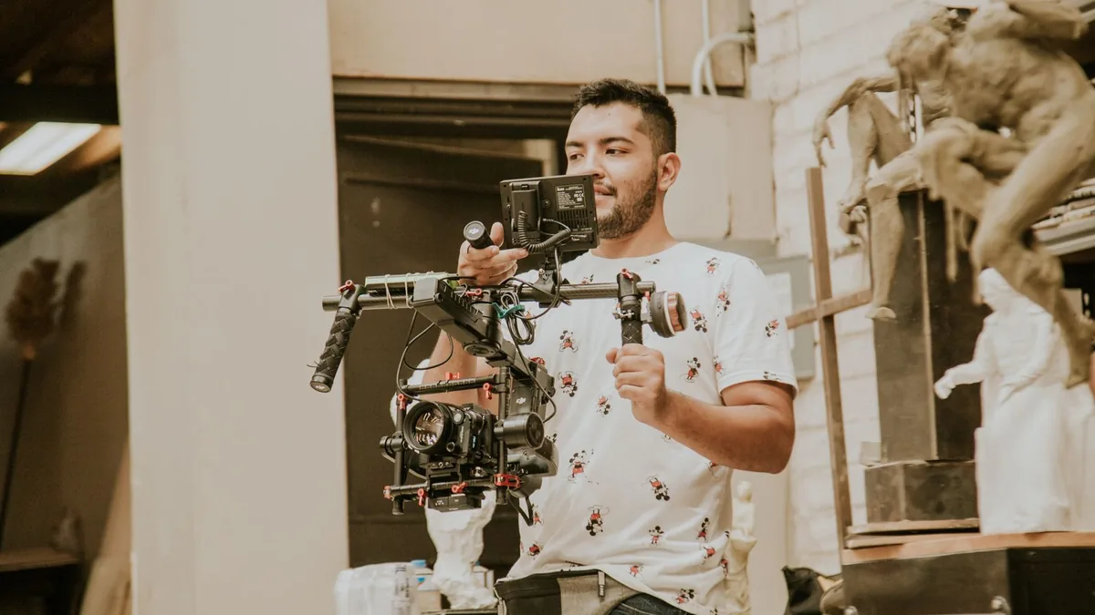 Videographer holding a stabilized camera rig, a factor in MSP video production cost