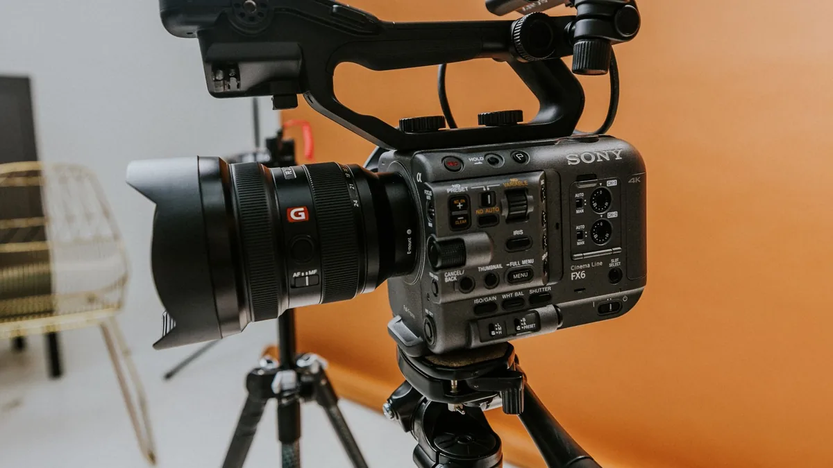 A cinema camera on a tripod set up in a small studio space