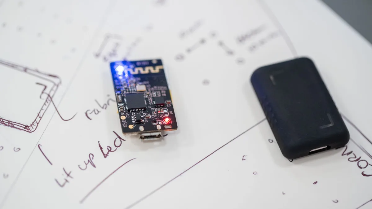 SBIR Phase 1 feasibility work: a prototype circuit board resting on hand-drawn design sketches