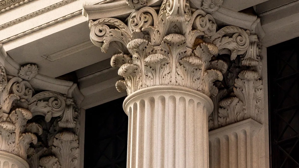Carved stone columns on a bank facade, a reminder that lenders underwrite a small business before capital advisory pays off
