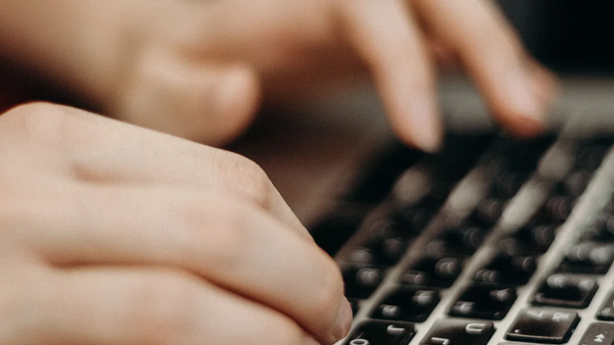 Close-up of hands typing on a laptop, a buyer running a Copilot search that Bing answers