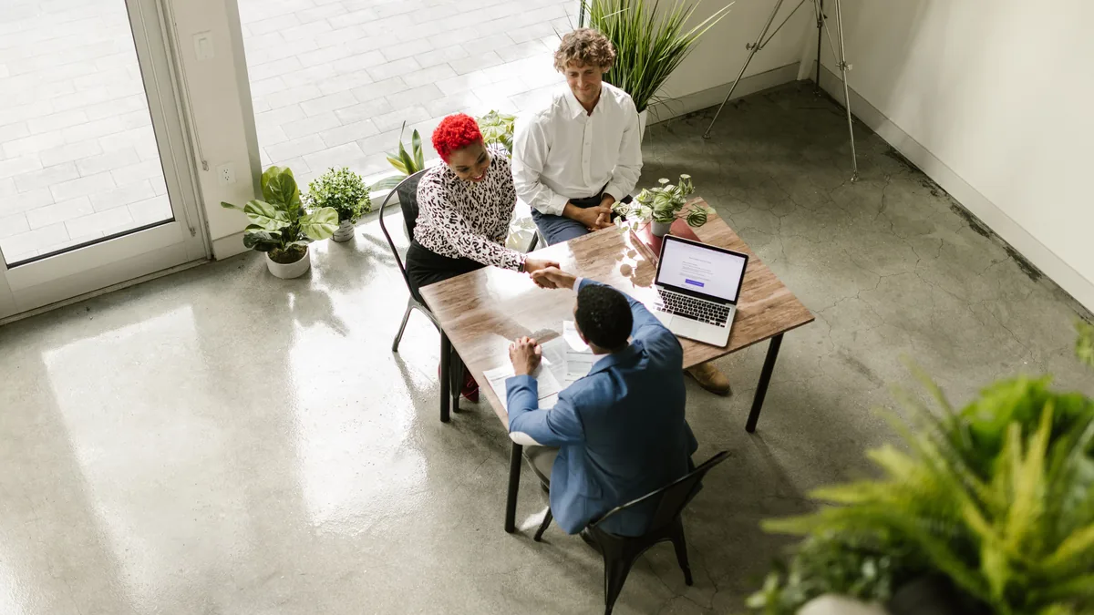 Team meeting around a table in a bright office, the Microsoft 365 workplace where Copilot answers questions