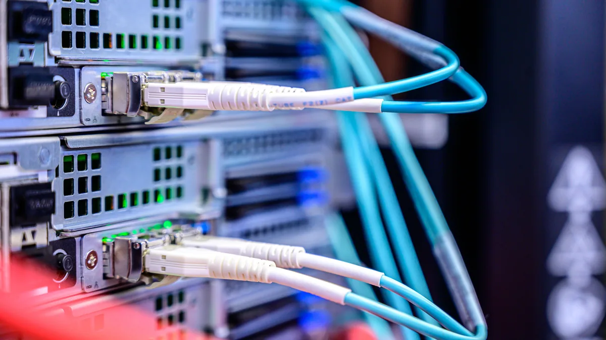Fiber patch cables plugged into a server, the client infrastructure a buyer inherits when buying an MSP