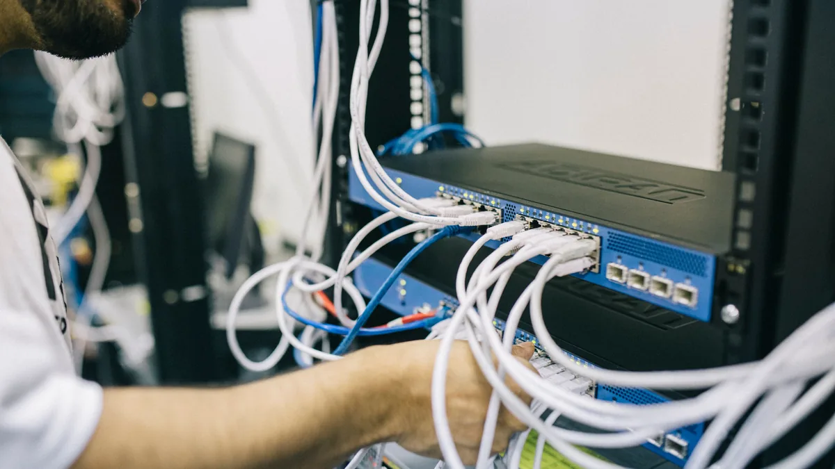 Technician working on network cabling in a rack, part of the team an MSP buyer needs to keep after closing
