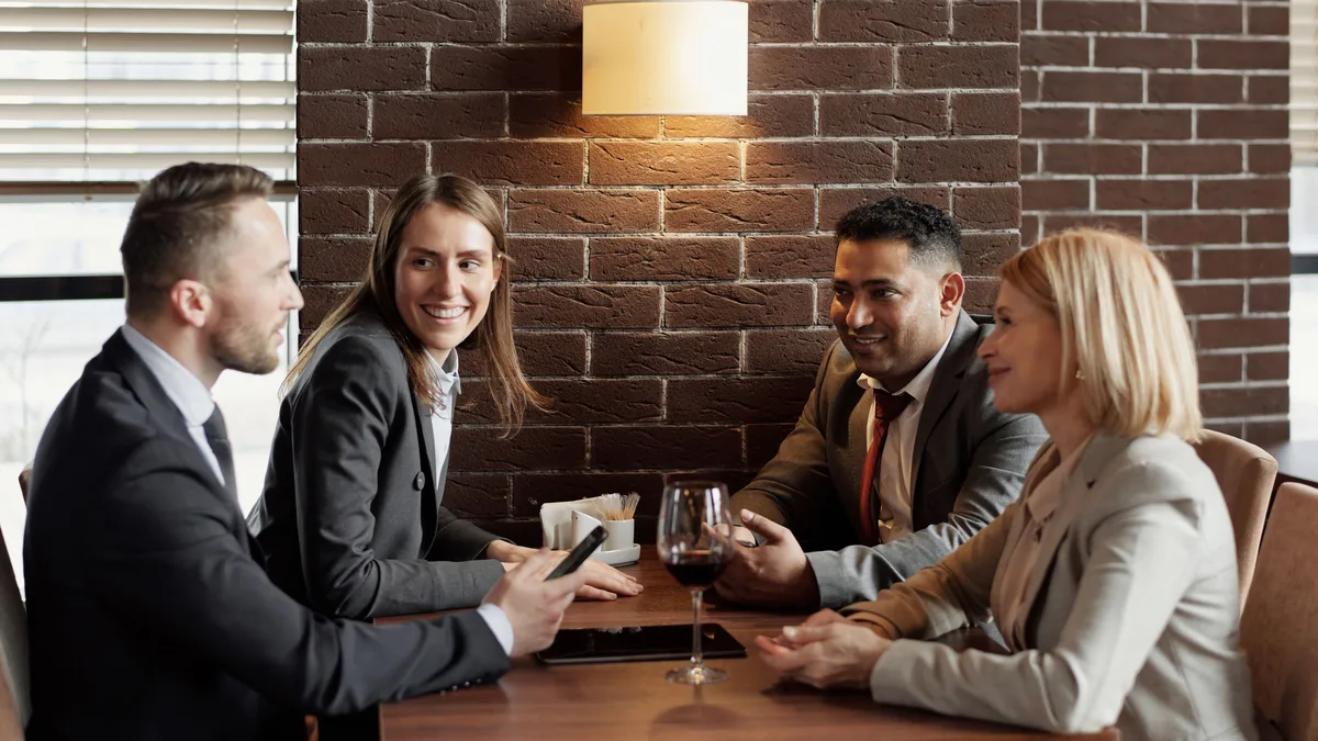 Business owners talking around a table at a local networking dinner, where MSP links and mentions start