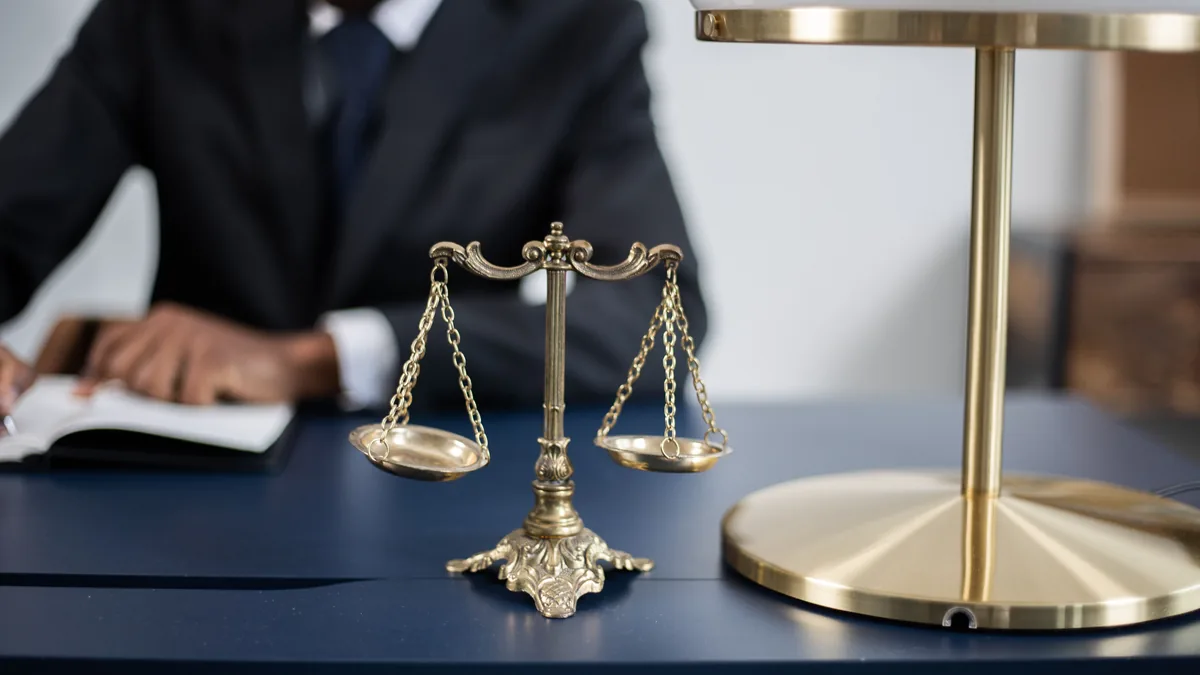 A small brass balance scale on a desk, a picture of weighing two IT options fairly