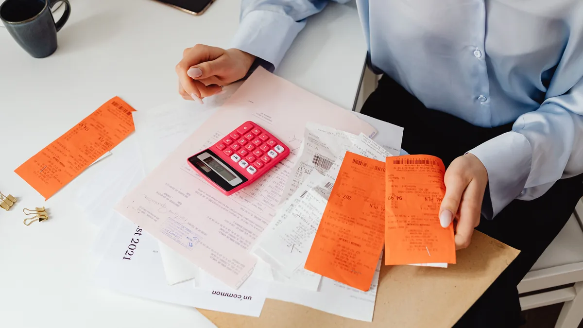 Owner sorting receipts with a calculator to document EBITDA add-backs before selling an MSP