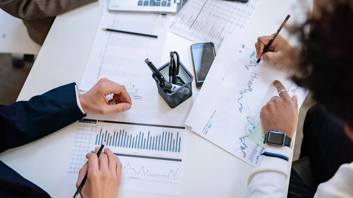 Owners marking up printed revenue charts while building an MSP financial forecast