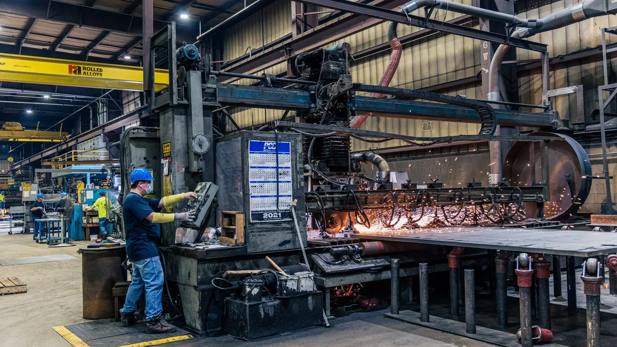 Worker running machinery on a factory floor, the buyer behind a manufacturing IT page for MSPs