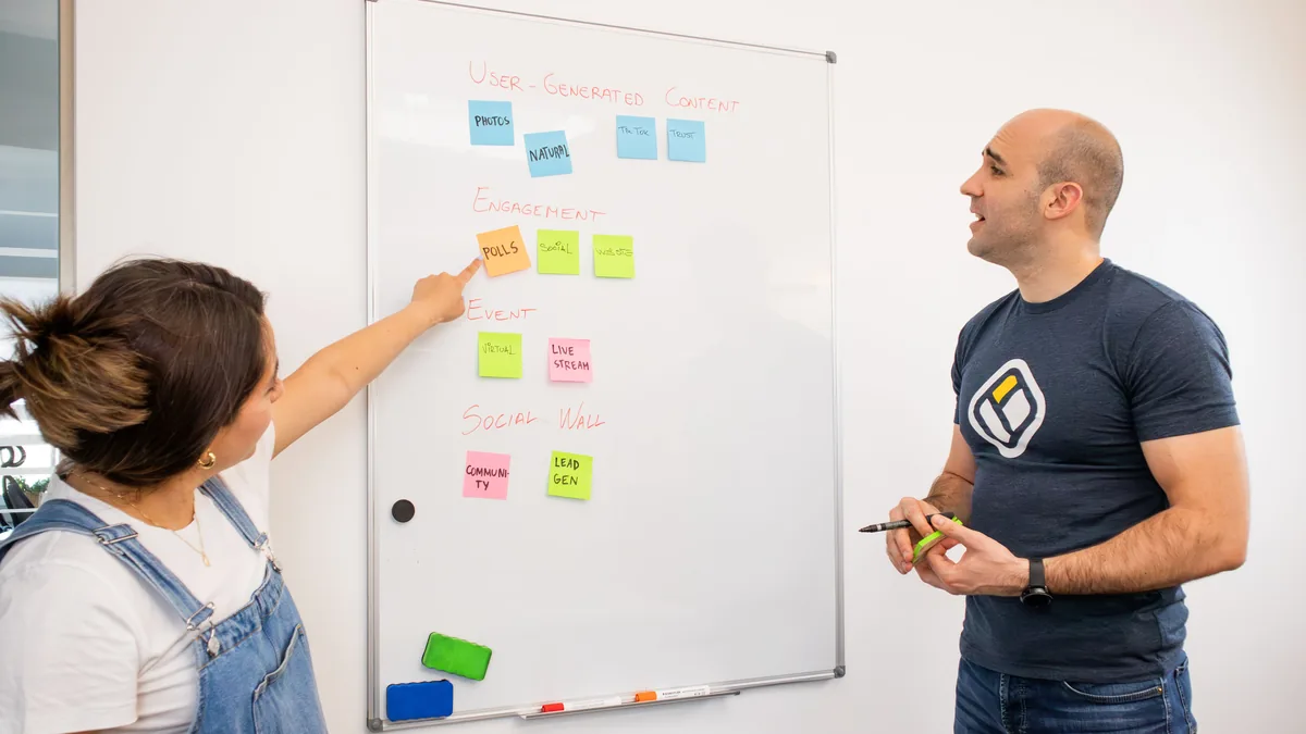 Two people mapping an MSP positioning statement on a whiteboard with sticky notes