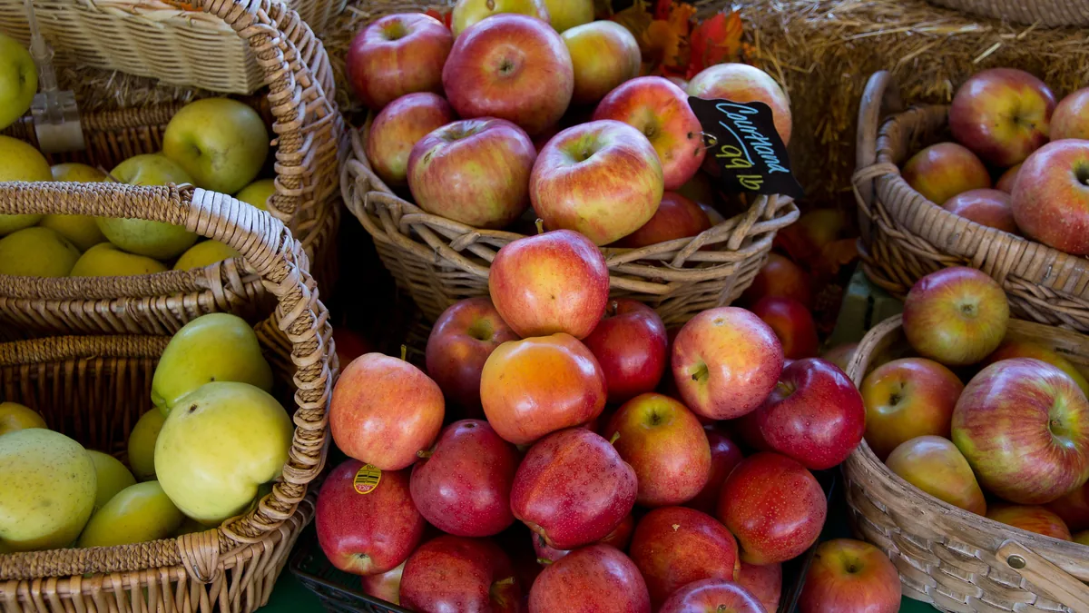 Baskets of red and green apples at a crowded market stall, a picture of how hard it is for an MSP to stand out without clear positioning
