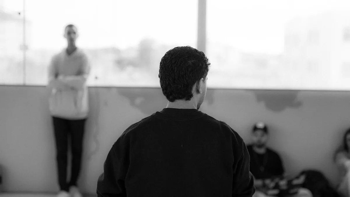 Black and white photo of people talking in a small group, the kind of community conversation AI tools quote