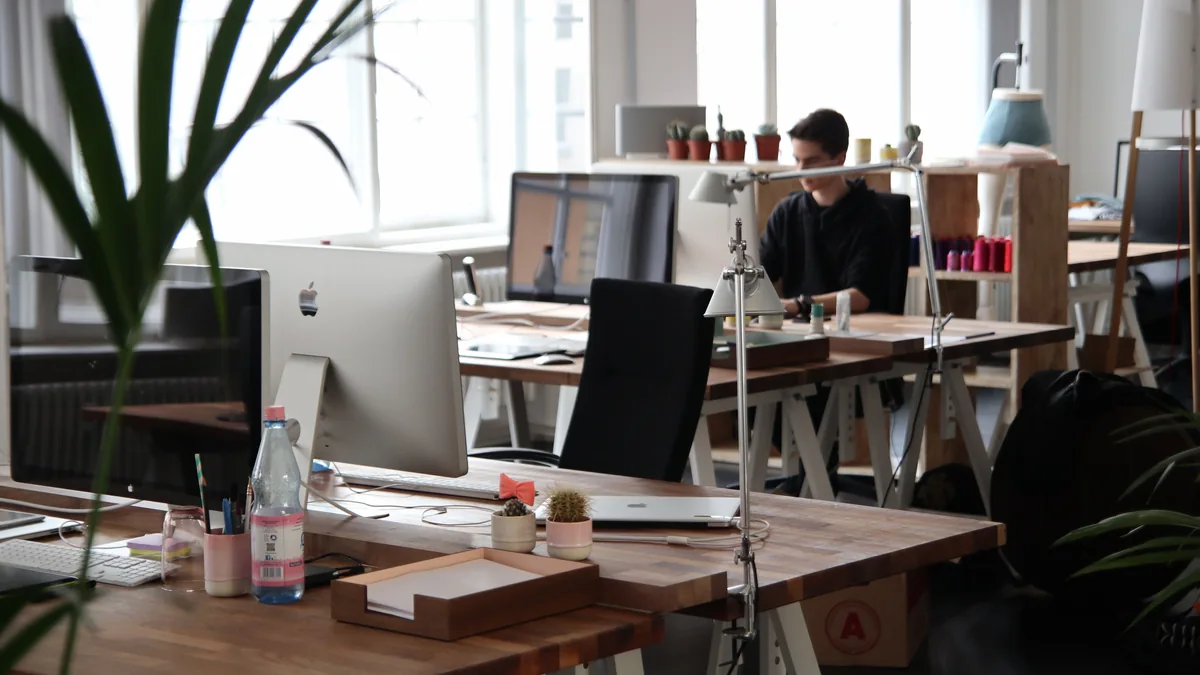 Desks and monitors in an open office, where an MSP's web person works through technical SEO fixes